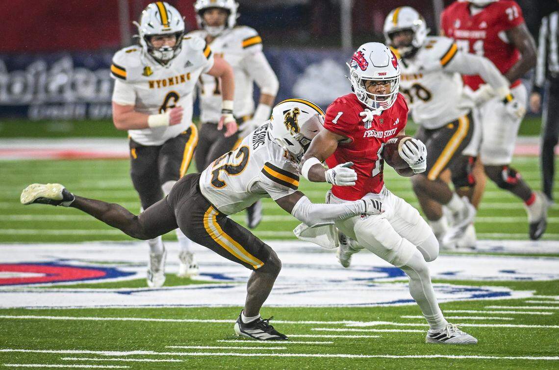 Fresno State’s Jahlil McClain, right, takes the ball downfield after a catch as Wyoming’s Desman Hearns tries to make the tackle during their game at Valley Children’s Stadium on Saturday, Nov. 16, 2025. 