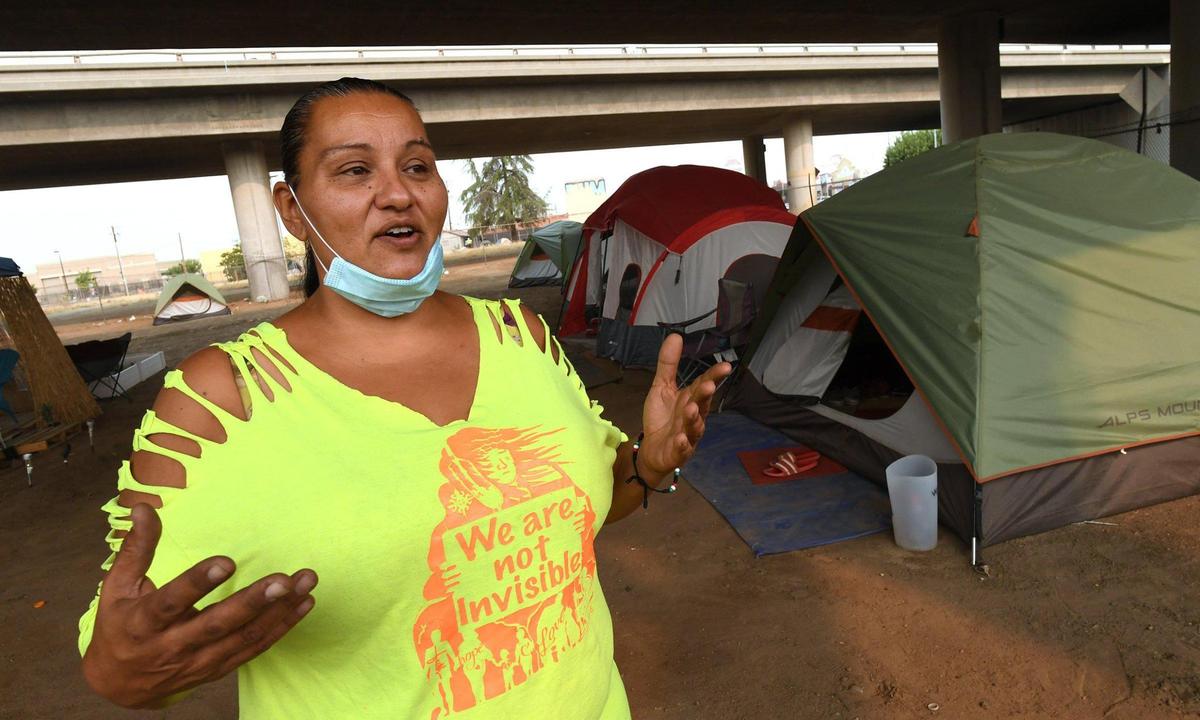 Bajo la Highway 41 en el centro de Fresno, Dez Martínez, activista a favor de los indigentes, habla el jueves 20 de agosto de 2020 sobre el campamento que montó, llamado Dream Camp por los habitantes, para ofrecer a las personas sin hogar una alternativa más segura y limpia a vivir en la calle. El campamento funcionó durante un año; Martinez lo cerró el pasado otoño.