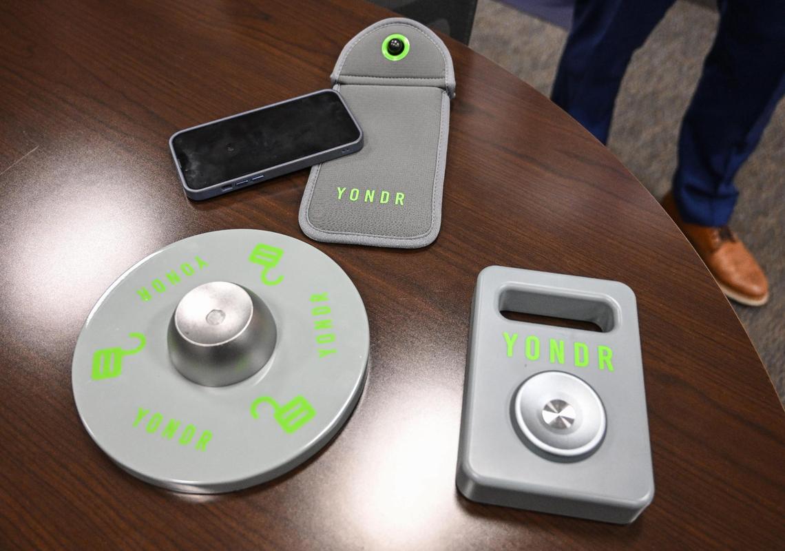 A Yondr pouch and magnetic unlocking devices are displayed at Bullard High School where the pouches are now mandatory for students throughout the school day. Phones go into the pouches and stay locked inside until after the school day ends.