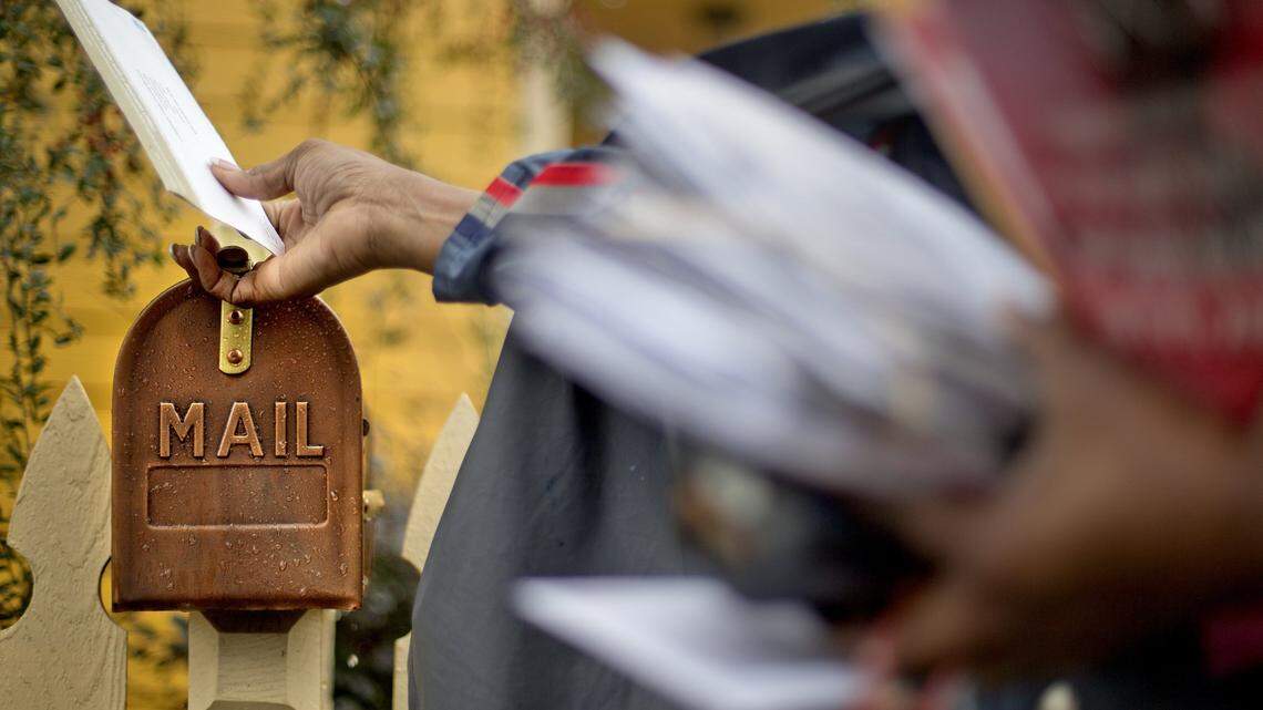 U.S. Postal Service letter carrier of 12 years, Jamesa Euler, delivers mail, Thursday, Feb. 7, 2013, in Atlanta. The financially struggling U.S. Postal Service wants to stop delivering mail on Saturdays but continue to deliver packages six days a week under a plan aimed at saving about $2 billion a year. (AP Photo/David Goldman)