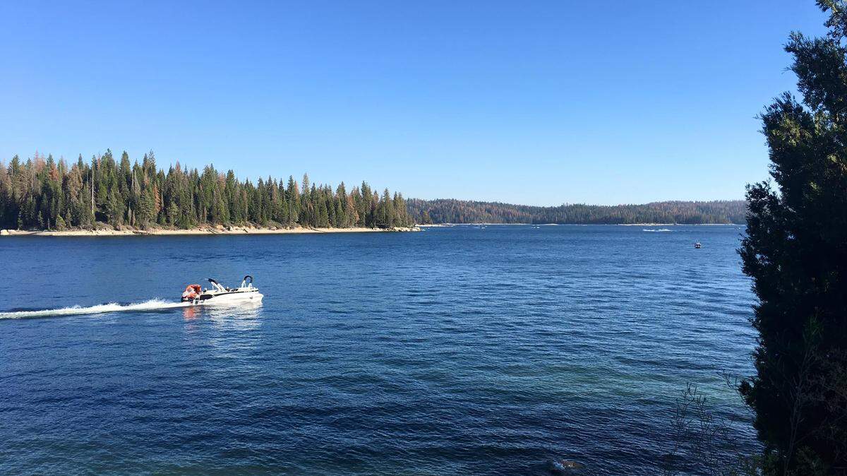 A boat heads across Shaver Lake on a beautiful summer day.