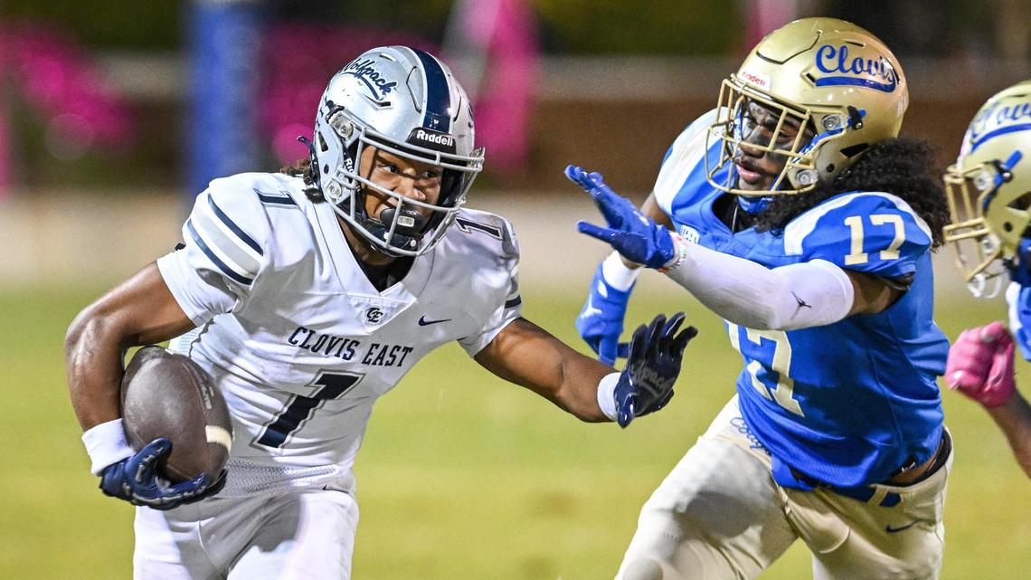 Clovis East’s Lindsey Graves, left, takes the ball on a carry and tries to get around the Clovis defense during their game at Lamonica Stadium on Friday, Oct. 18, 2024.
