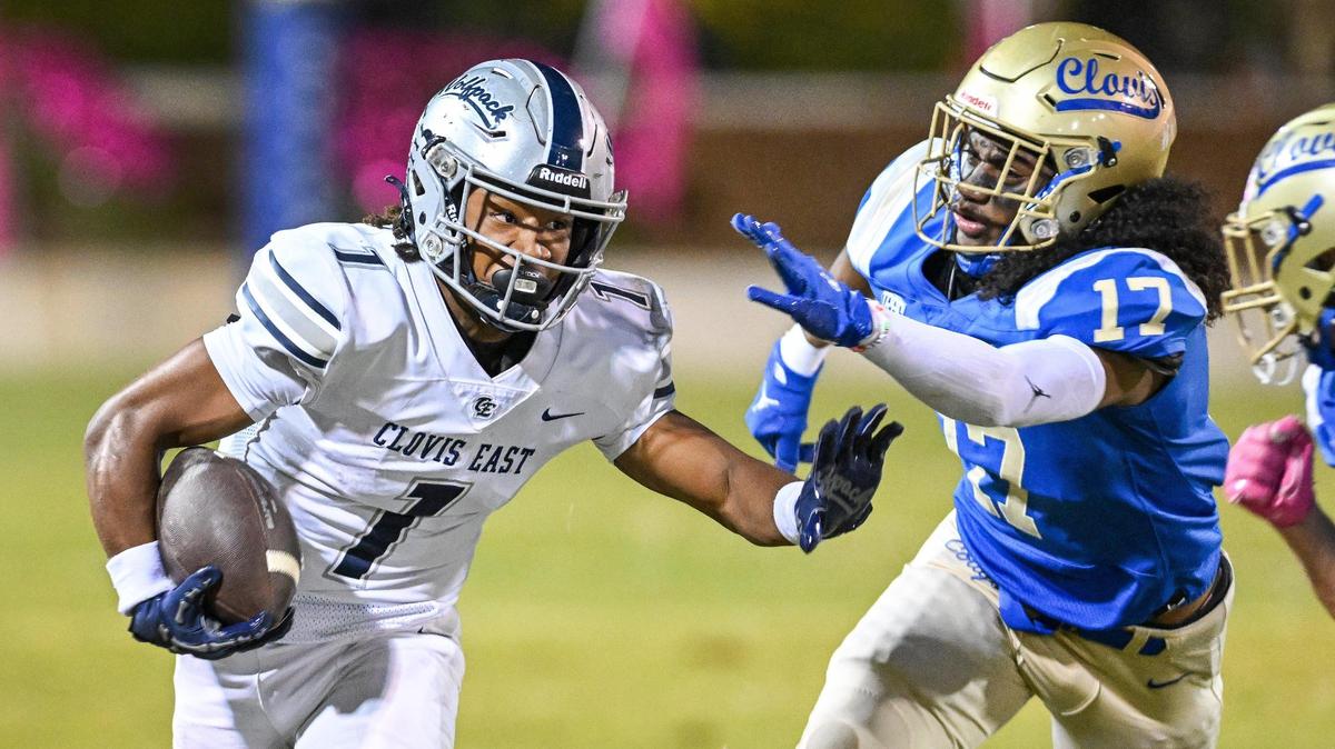 Clovis East’s Lindsey Graves, left, takes the ball on a carry and tries to get around the Clovis defense during their game at Lamonica Stadium on Friday, Oct. 18, 2024.