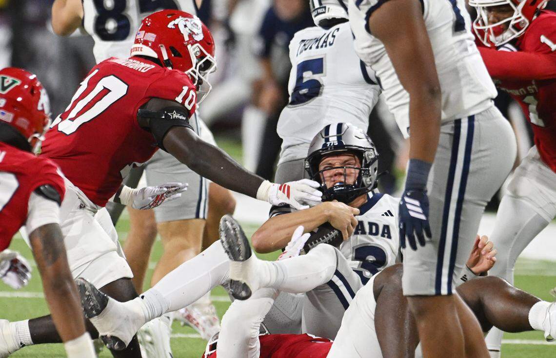 Nevada's quarterback Chubba Purdy, center, is sacked by the Fresno State defense in the first half Saturday, Oct. 4, 2025 in Fresno.
