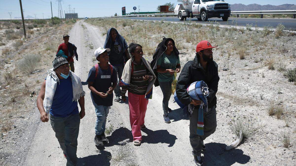 A group of migrants walk alongside a highway near Chihuahua City on their way to the United States on April 16, 2024. / Un grupo de migrantes caminan a un costado de la carretera rumbo a la frontera con Estados Unidos, el 16 de abril de 2024, en la ciudad de Chihuahua.