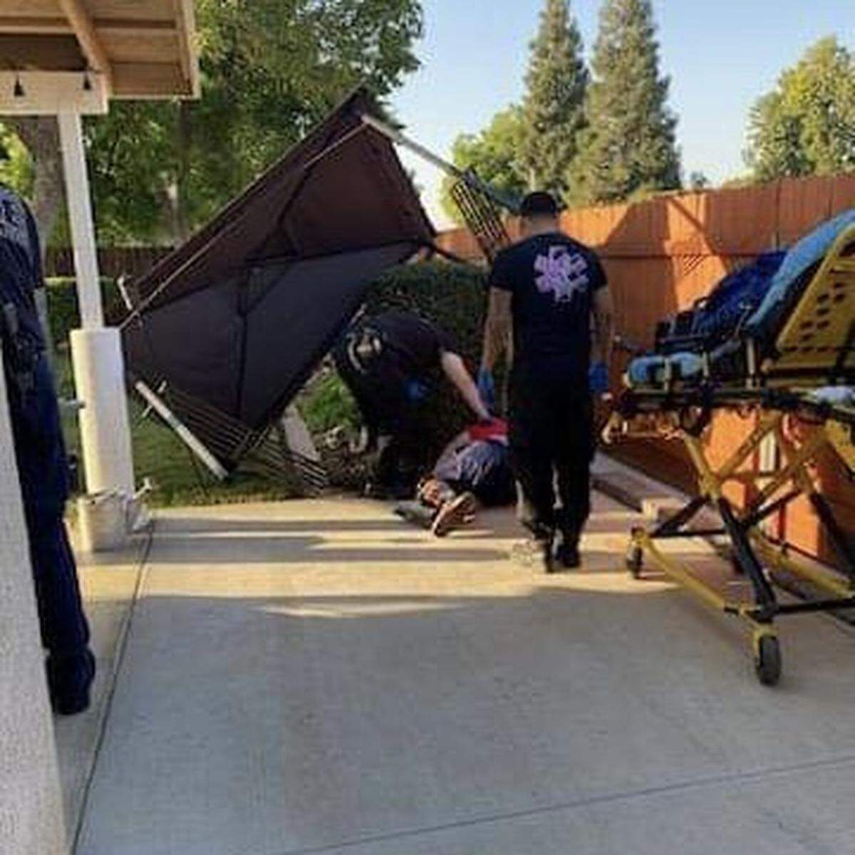 EMS arrives to aid Strathmore High football coach Jeromy Blackwell after he fell on June 30, 2023.