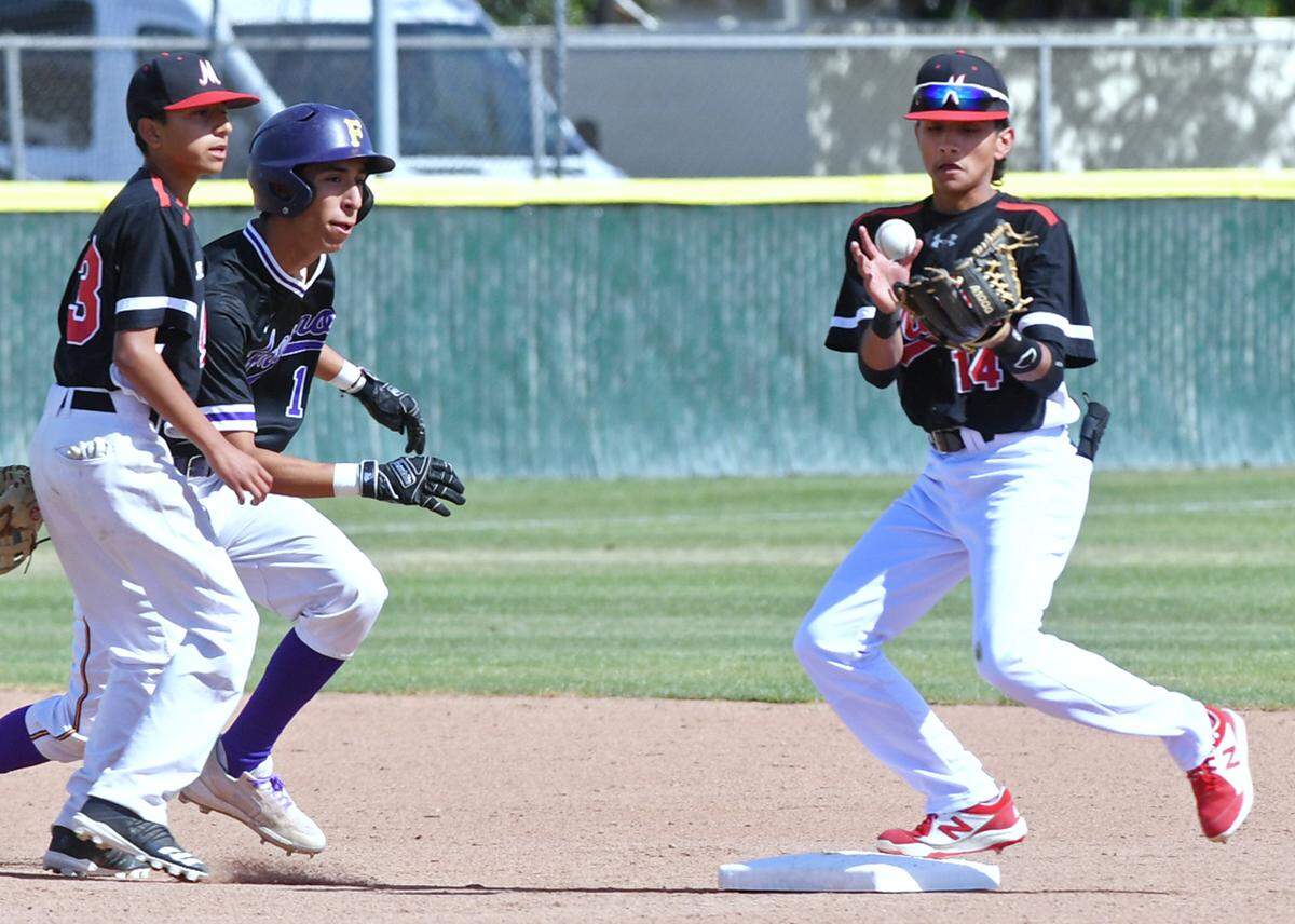 McLane’s Benny Hernandez, right, catches the ball for an out of Fresno High’s Dominik Espinosa, center, at second base in a matchup Friday, April 22, 2022 in Fresno.