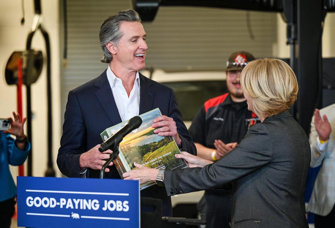 Ashely Swearengin, president and CEO of the Central Valley Community Foundation, hands California Governor Gavin Newsom a binder detailing the Sierra San Joaquin Jobs Initiative during a press event announcing a jobs creation plan to bolster the state’s economy at Fresno City College’s west campus on Thursday, Nov. 21, 2024.