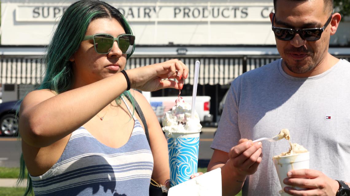 Eva Gonzales, of Fresno enjoys a banana split and Julio Torres with a scoop of coffee ice cream outside of Superior Dairy in Hanford, California on Wednesday, March 26, 2025. The beloved ice cream spot, a landmark in the Central Valley since 1929, has new owners - the Zonneveld family, a local dairy family with deep roots in Kings County. 