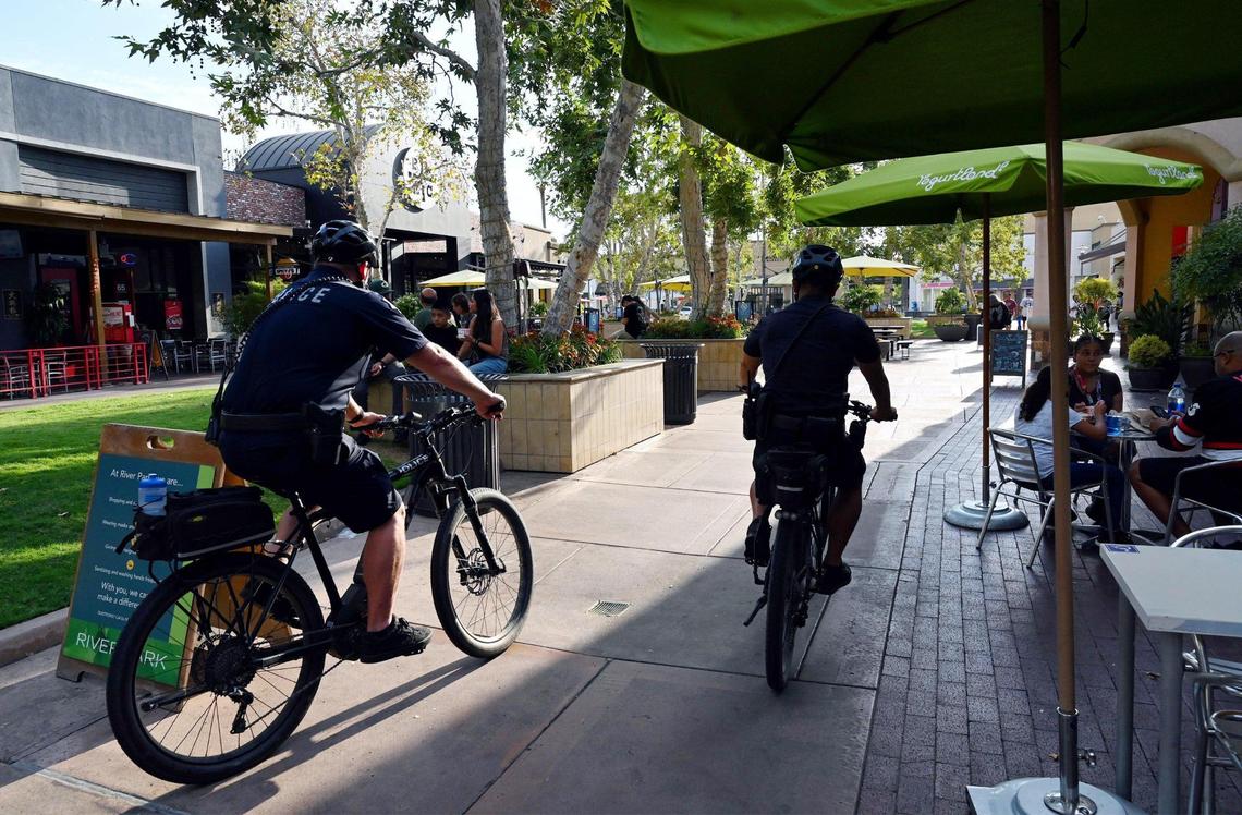 Fresno police officers Dustin Freeman, left, and Luke Tran, right, patrol River Park late Saturday afternoon, July 30, 2022 in Fresno.