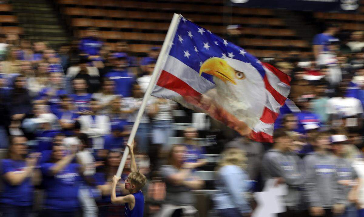 Immanuel High fan James Bartel, 8, was busy flying the school flag during his team’s 41-29 win over Mendota High in the CIF Central Section Division IV championship game at Selland Arena on Feb. 23, 2024. / James Bartel, de 8 años, aficionado de Immanuel High, estuvo ocupado enarbolando la bandera de la escuela durante la victoria de su equipo por 41-29 sobre Mendota High en el partido por el campeonato de la División IV de la Sección Central de CIF en Selland Arena el 23 de febrero de 2024.