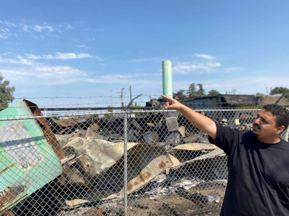 Ezize Hassan, 30, points to the tree that Poplar, CA residents said ignited the July 9 fire.