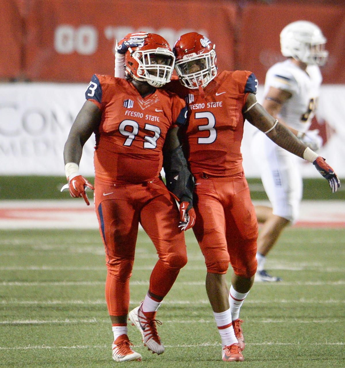 Fresno State defensive tackle Jasad Haynes, left, and end Mykal Walker celebrate a second half sack in a 49-27 victory over the Toledo Rockets at Bulldog Stadium on Saturday, Sept. 29, 2018.