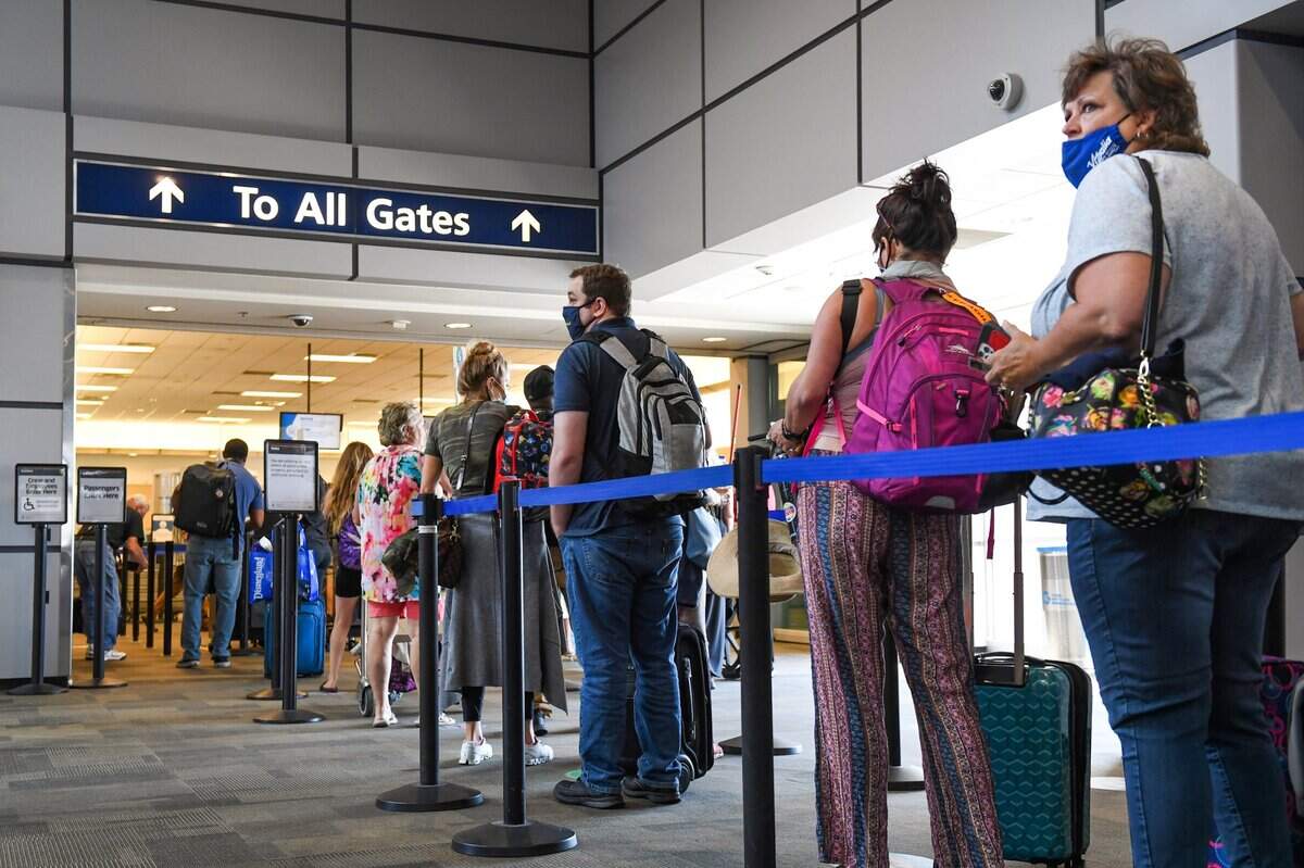 Passengers wait in line to go through the Transportation Security Administration checkpoint at Fresno Yosemite International Airport in this June 2021 file photo.
