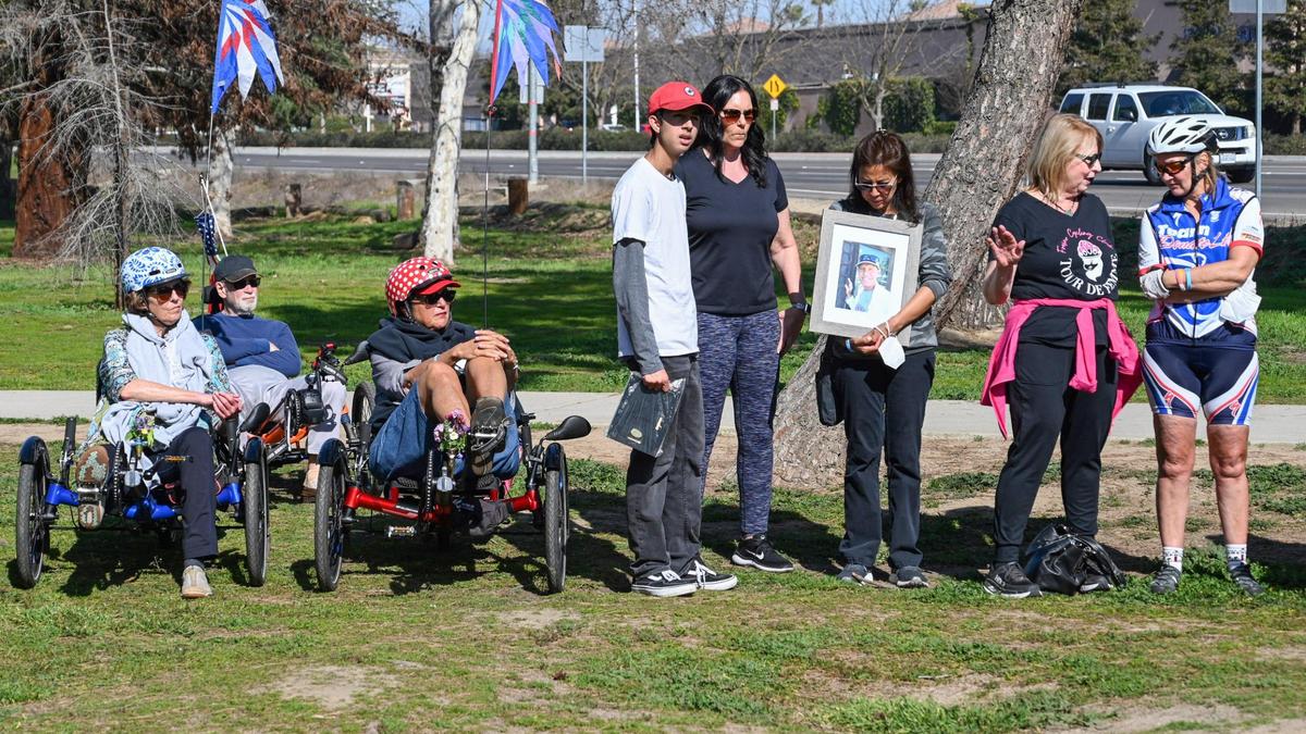 Cyclists and others listen to Fresno Mayor Jerry Dyer speak about safety measures that will be taking place along Friant Road near Woodward Park in Fresno during a news conference on Thursday, Feb. 10, 2022.