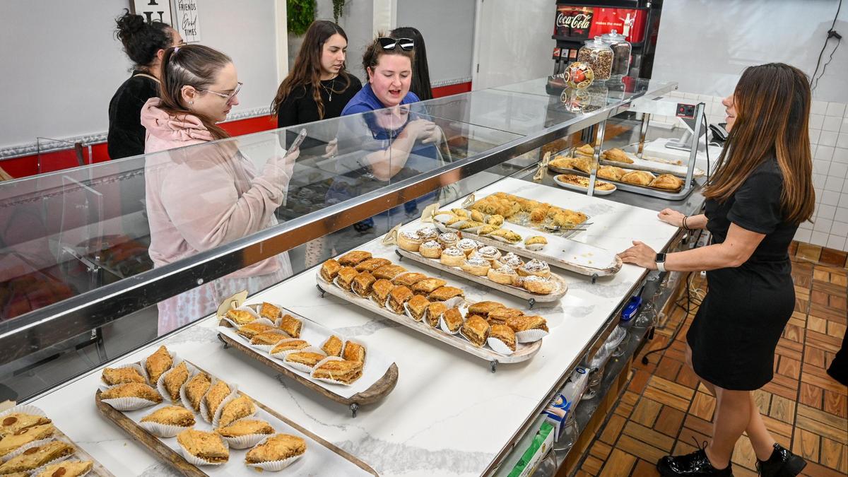 Karine Sahakyan, right, assists customers with choices of baklava at Baklava House, now open on Bullard Avenue near West Avenue in Fresno.