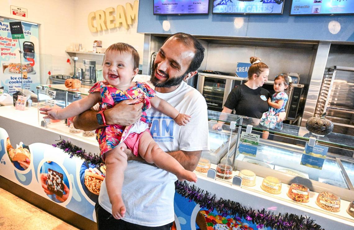 Gurvinder Sandhu holds 9-month-old daughter Madilyn “Madi” Sandhu while his wife Amanda Vogel holds their 2-year-old Evelyn Sandhu at the CREAM ice cream business they recently purchased and are running instead of their Twisted Masala food truck.