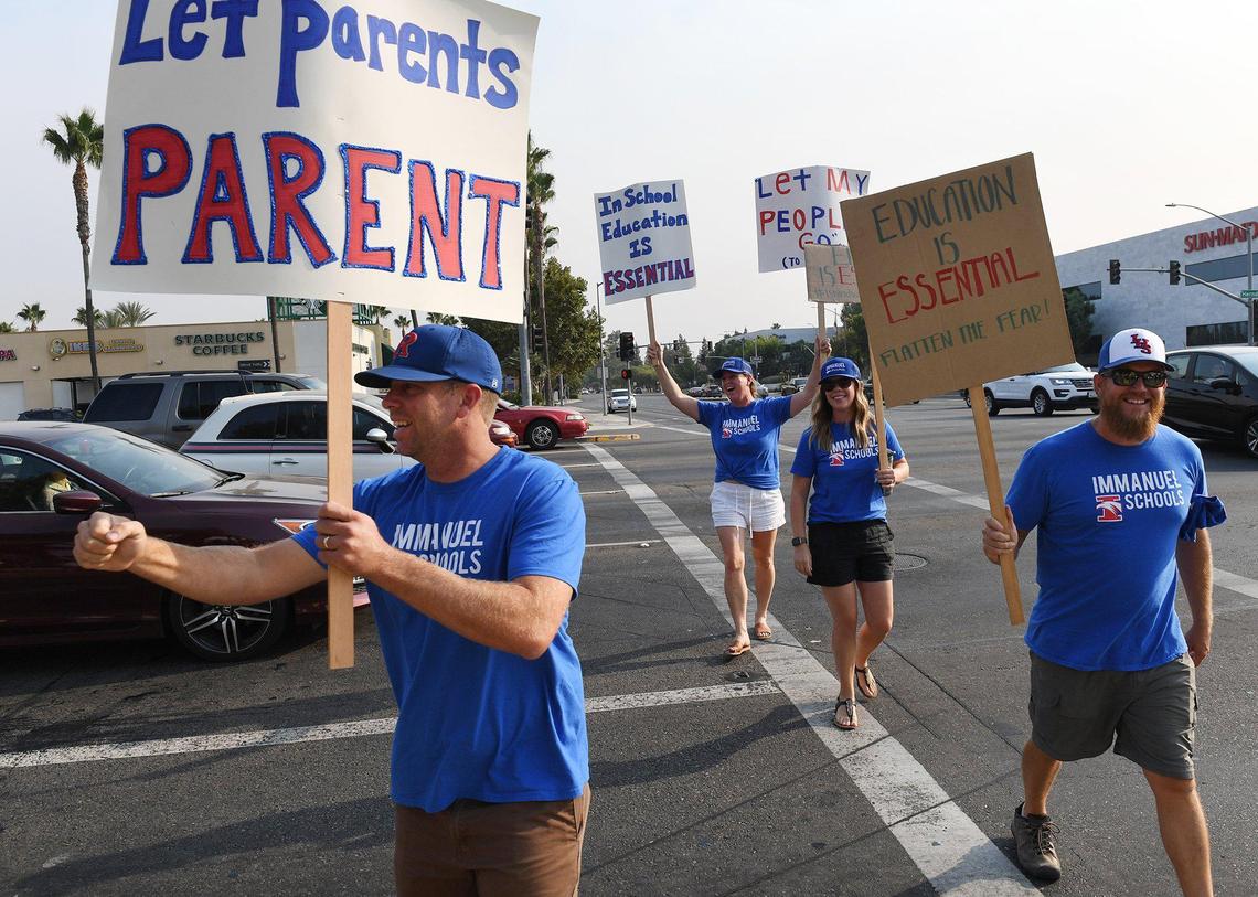 Immanuel Schools suppoters join aover 100 parents, children and supporters gathered on the northeast corner of Herndon and Palm Avenues to urge re-opening of schools Thursday, Sept. 3, 2020 in Fresno.