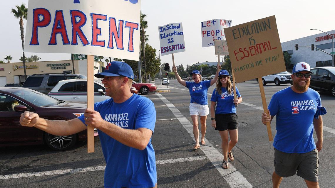 Immanuel Schools supporters join over 100 parents, children and supporters at the northeast corner of Herndon and Palm Avenues to urge re-opening of schools Thursday, Sept. 3, 2020 in Fresno.