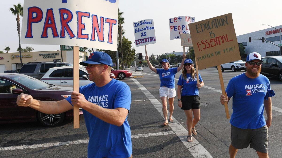 Immanuel Schools supporters join over 100 parents, children and supporters at the northeast corner of Herndon and Palm Avenues to urge re-opening of schools Thursday, Sept. 3, 2020 in Fresno.