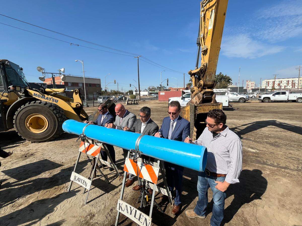 Dignitaries, from left, Assemblymember Joaquin Arambula, Fresno Mayor Jerry Dyer, Fresno City Councilmember Miguel Arias, Public Utilities Director Brock Buche and developer Reza Assemi sign a piece of pipe symbolizing the start of construction to upgrade water and sewer lines in downtown Fresno and the neighboring Chinatown district. The ceremony at the corner of Tulare and E streets was held Wednesday, Oct. 30, 2024.