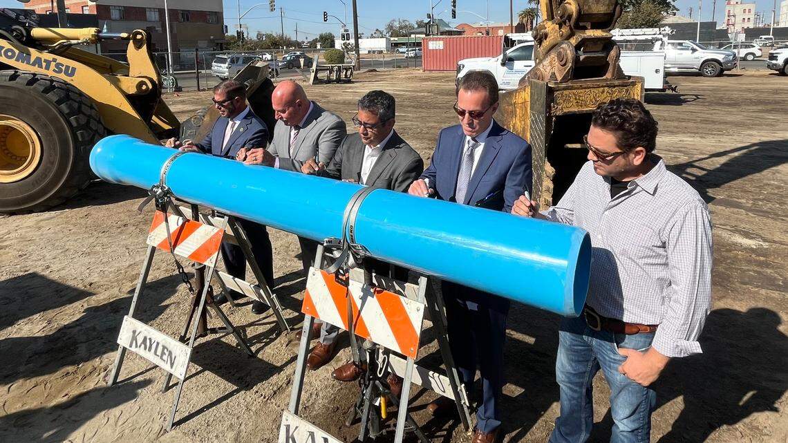 Dignitaries, from left, Assemblymember Joaquin Arambula, Fresno Mayor Jerry Dyer, Fresno City Councilmember Miguel Arias, Public Utilities Director Brock Buche and developer Reza Assemi sign a piece of pipe symbolizing the start of construction to upgrade water and sewer lines in downtown Fresno and the neighboring Chinatown district. The ceremony at the corner of Tulare and E streets was held Wednesday, Oct. 30, 2024.