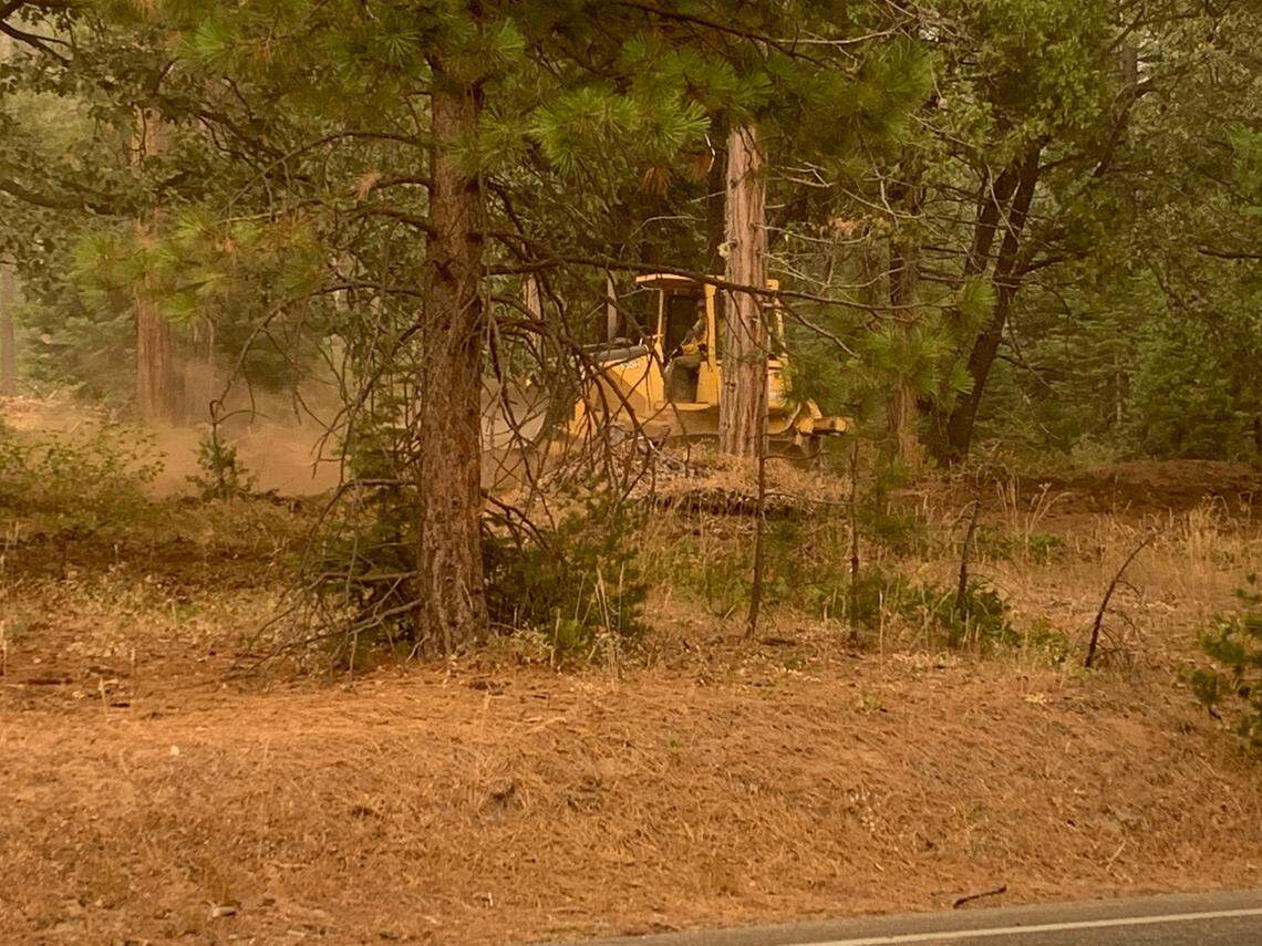 A bulldozer works in the Camp Nelson area to clear brush that could serve as fuel for the approaching Creek Fire on Sunday, Sept. 6, 2020.