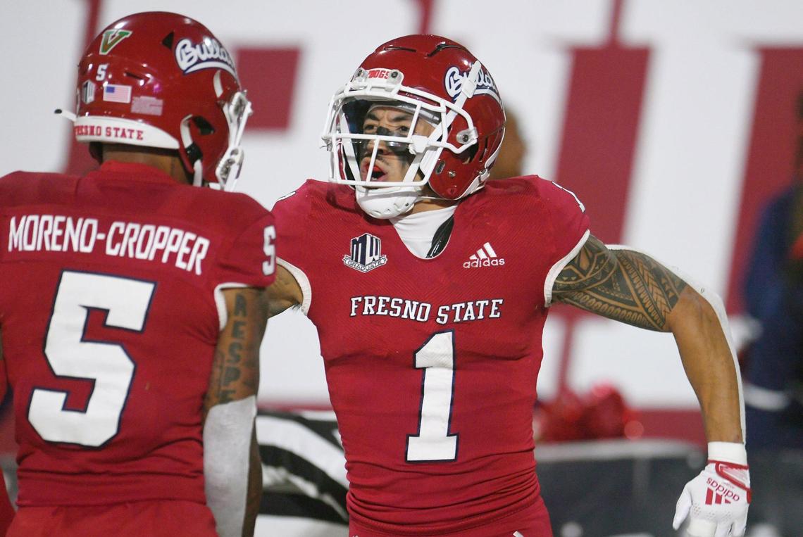 Fresno State’s Nikko Remigio, right, celebrates his touchdown against Wyoming with Jalen Moreno-Cooper to the left, Friday, Nov. 25, 2022 in Fresno. The Bulldogs led 23-0 at halftime.