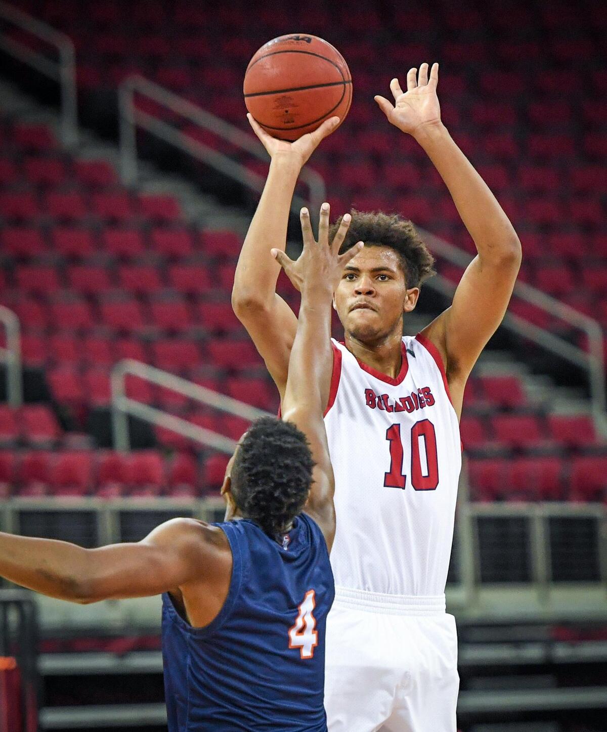 Fresno State forward Orlando Robinson, right, eyes a jump shot over Fresno Pacific’s Aamondae Coleman in the first half of their game at the Save Mart Center in Fresno on Saturday, Dec. 19, 2020.