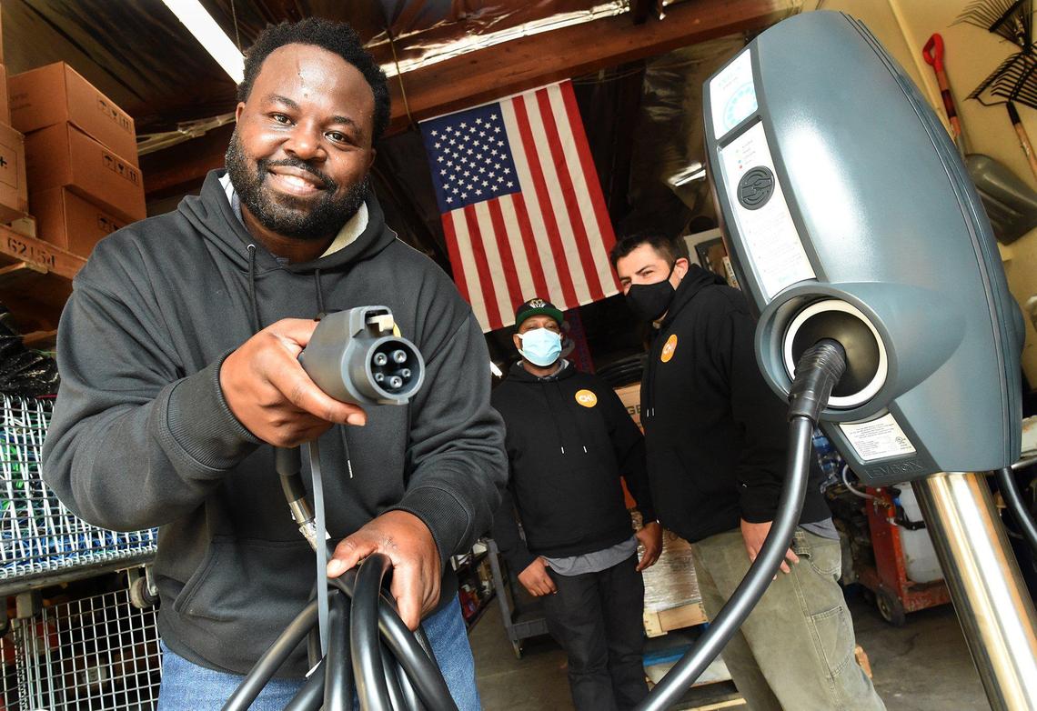 Clyde Ellis, ChargerHelp! EV trainer, shows the charger plug from an electric vehicle charging station, right, Thursday, Feb. 11, 2021 at the company’s Fresno warehouse. ChargerHelp! is the first and only on-demand repair app for EV charging stations and will begin hiring for technician jobs for maintenance of EV stations. ChargerHelp! founders, who served on President Joe Biden’s clean technology committee during the 2020 election, have aligned this workforce program with President Biden’s current spending pledge to address climate change, which will in turn create new jobs.