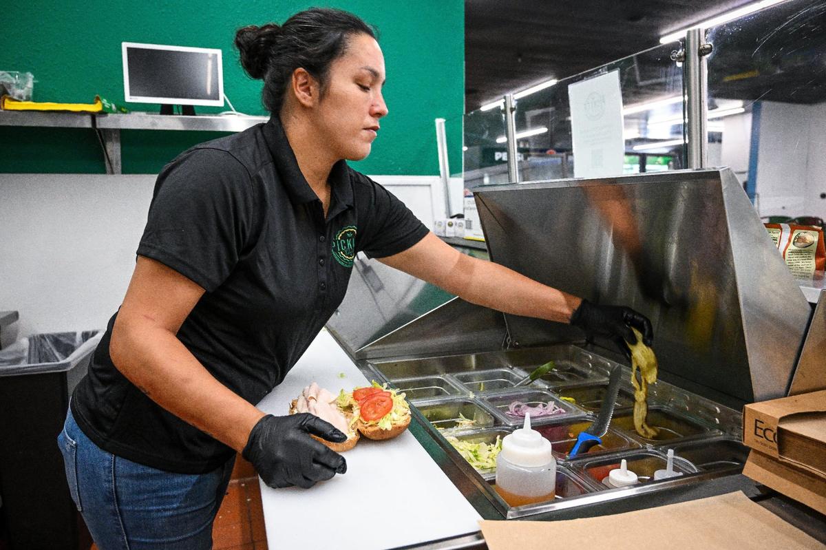 Salina Segura prepares a sandwich at the Pickled Deli, which is one of the new offerings at Peacock Artisan Eatery inside the decades-old Peacock Market in Clovis.