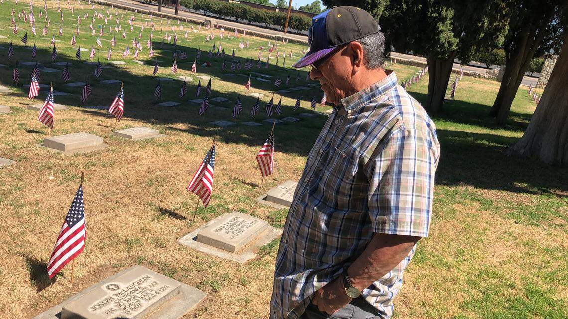 John Mendez Jr, 79, visits the graves of his father and mother at the military cemetery on Belmont Avenue, west of Highway 99, on Sunday, May 24, 2020, during the Memorial Day Holiday weekend.