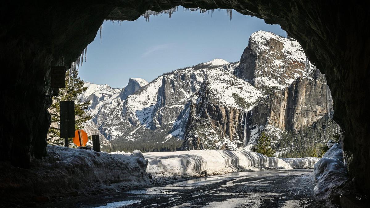 Yosemite’s iconic tunnel view unveils an unusually quiet snowy winter scene with banks piled high with snow and ice covering many of the roadways on Friday, March 3, 2023. The park has closed indefinitely due to recent heavy snowfall.