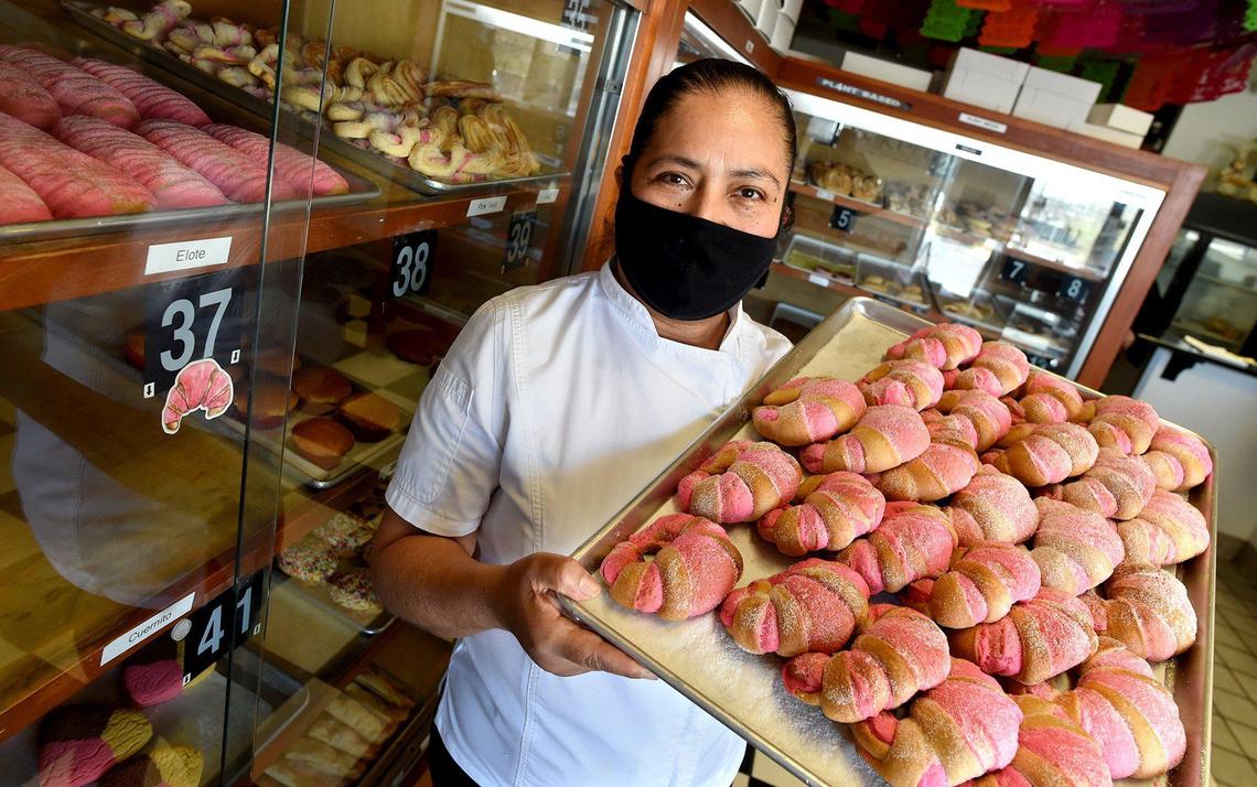 Eugenia Garcia, owner of Panderia Cafe Oaxaca in Clovis, holds a tray of freshly baked pastries on Feb. 15. The business has been impacted by the pandemic, inflation and supply chain issues.
