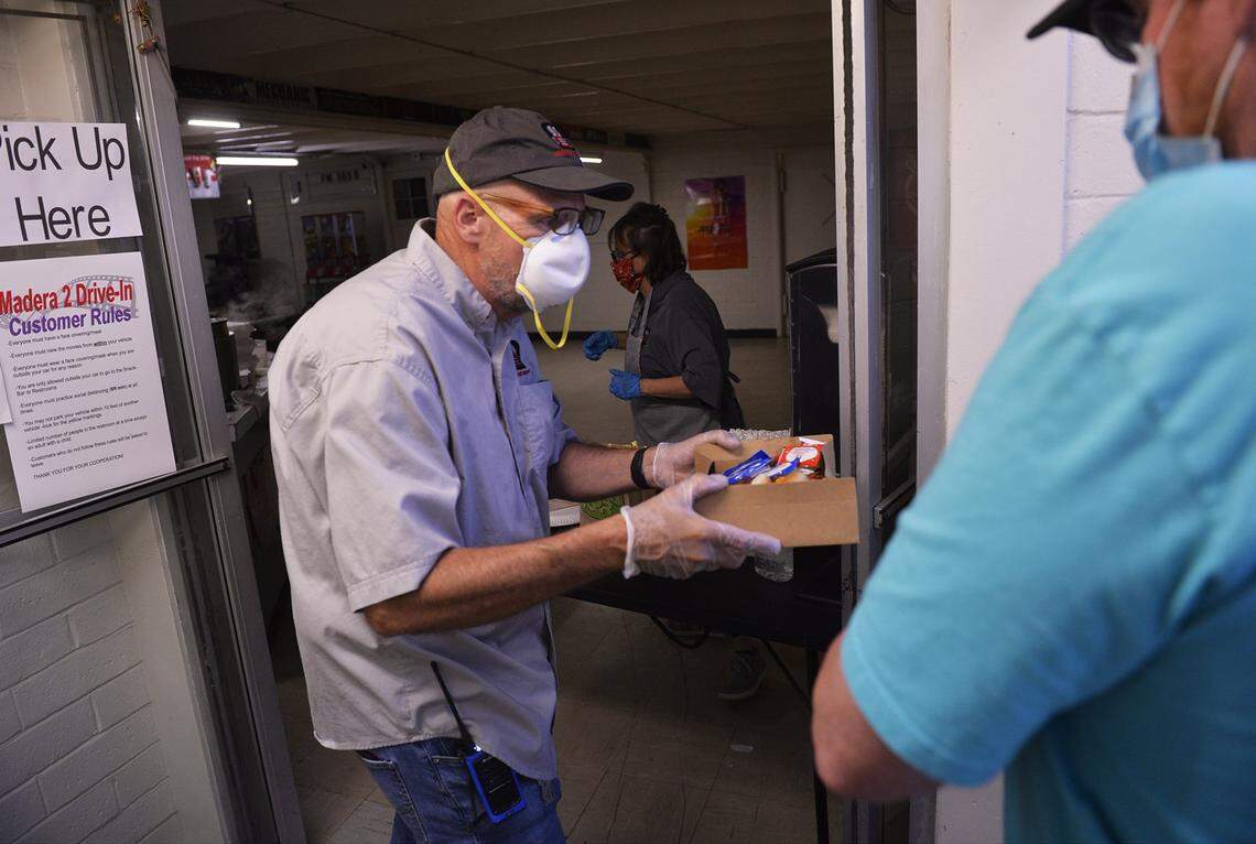 Madera 2 Drive-In owner Bob Gran, Jr. left, serves food at the snack bar Friday, May 22, 2020 in Madera.