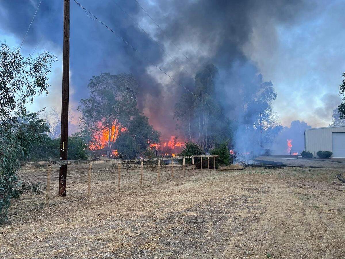 A grass fire spread to a home, injuring a person on Tuesday, May 31, 2022.
