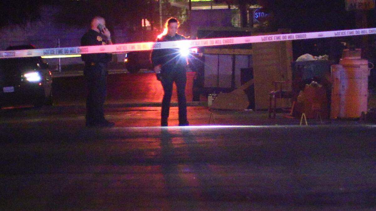 Police search a scene after three people were shot late Sunday, Aug. 13, 2023, near Locust and College avenues.