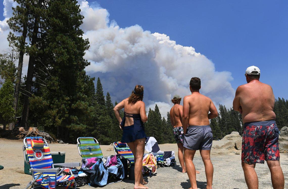 A family from Ventura County watches the billowing smoke of the Creek Fire from the shore of Shaver Lake Saturday, Sept. 5, 2020.