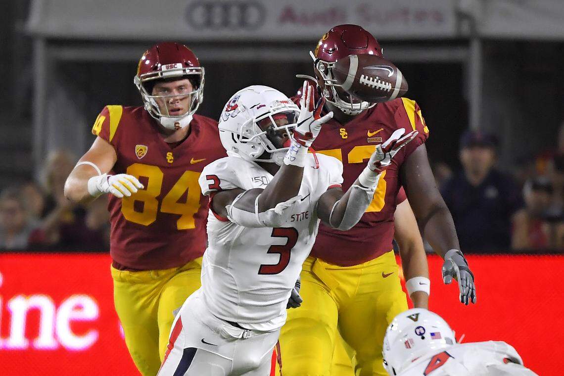 Fresno State linebacker Mykal Walker, center, almost intercepts a pass as Southern California tight end Erik Krommenhoek, left, and offensive tackle Drew Richmond watch during the first half of an NCAA college football game Saturday, Aug. 31, 2019, in Los Angeles. Walker dropped the ball after colliding with another player. (AP Photo/Mark J. Terrill)
