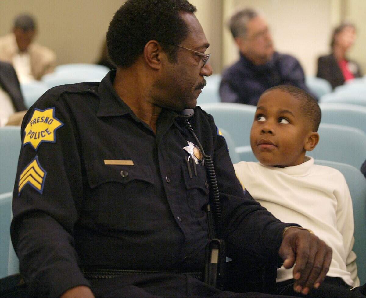 Fresno police Sgt. Freeman Hunter and his grandson Kaleb Jennings, 5, wait for the Martin Luther King Jr. Unity Committee awards ceremony to begin at Fresno City Hall on Jan. 14, 2005. Hunter was honored with the committee’s Law Enforcement Award.