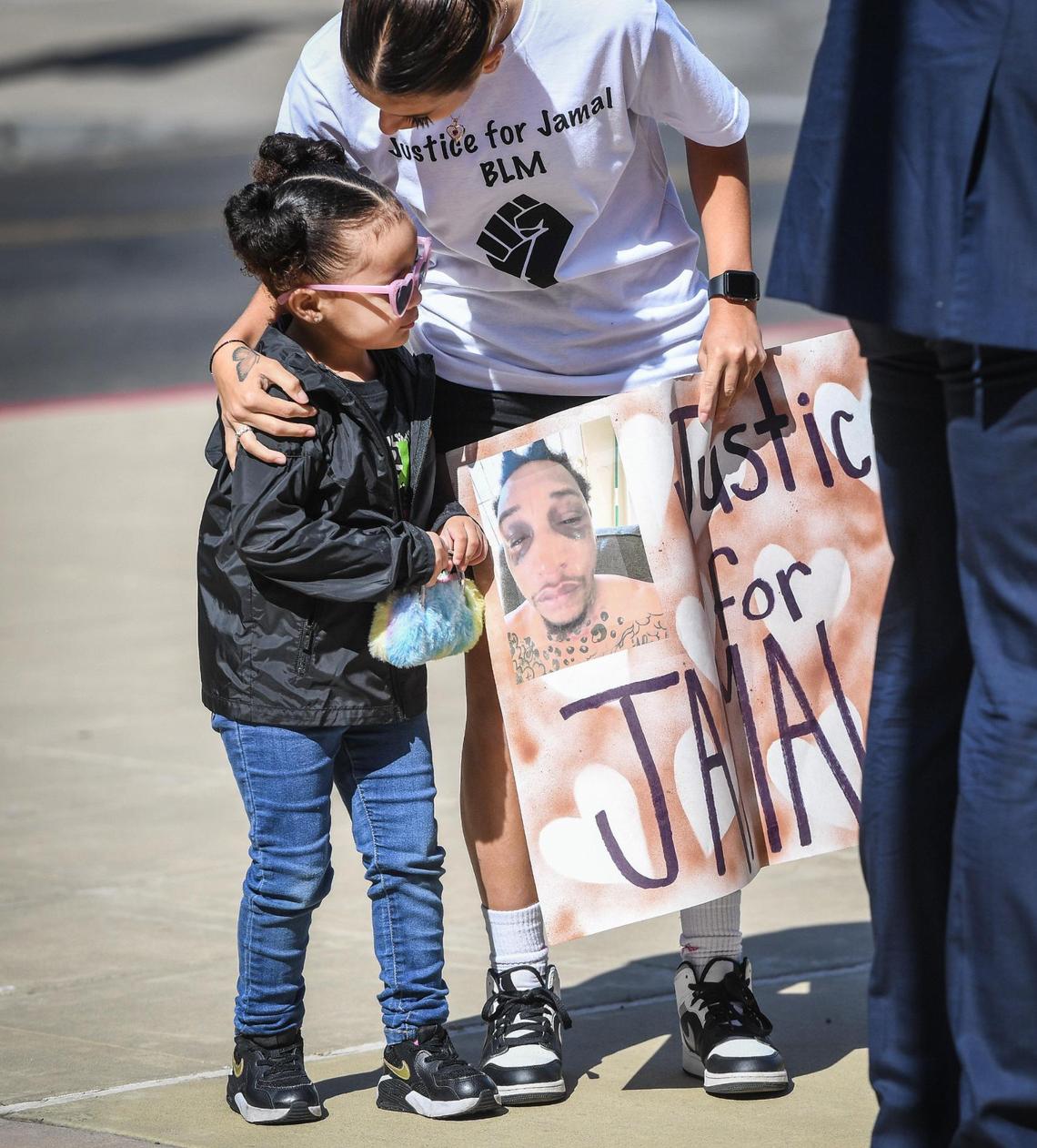 Supporters of Jamal Jones arrive at a news conference with a sign and photo showing Jones’ injuries after a traffic stop last year, before lawyers for Jones announced a lawsuit with be filed against the Clovis Police Department, accusing the department of racial profiling, excessive force and severe injury from a police canine, outside the Robert E Coyle Federal Building in downtown Fresno on Thursday, April 28, 2022.