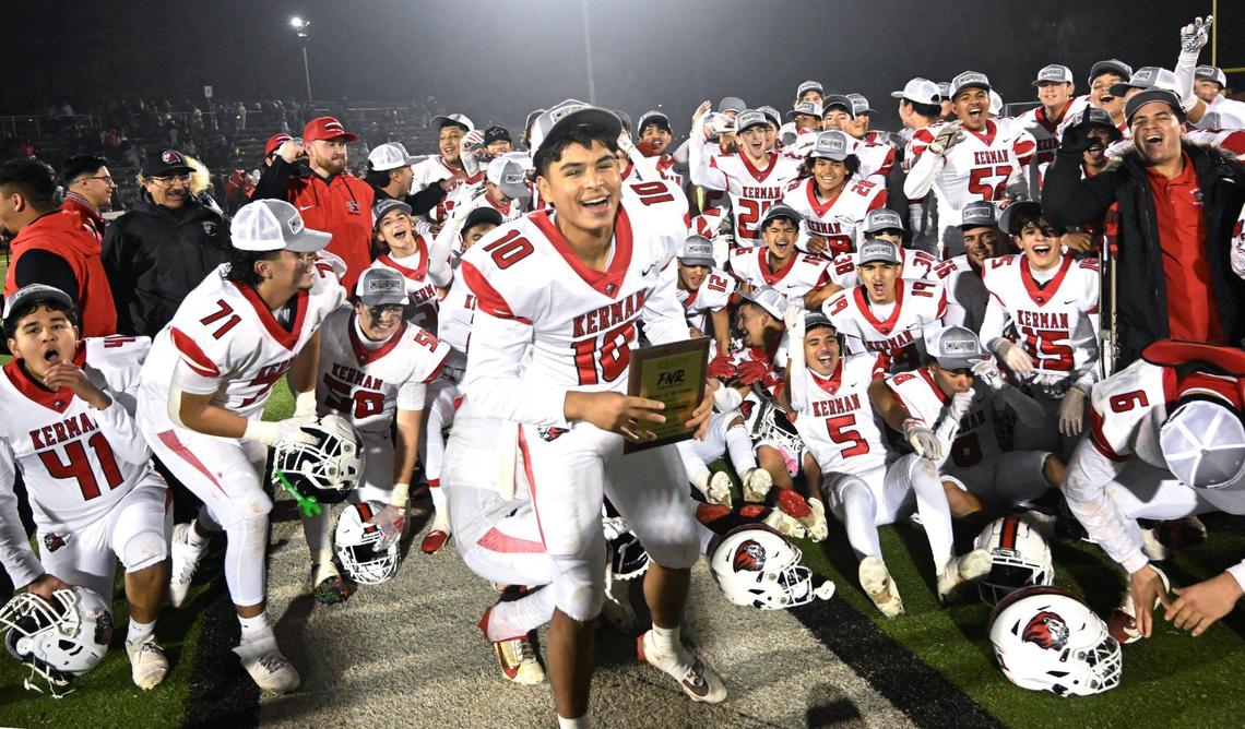 Kerman quarterback Adrian Torres, center, with the team behind him, celebrate Kerman’s 42-28 win over Madera for the Central Section DIII championship Friday, Nov. 29, 2024 in Madera.