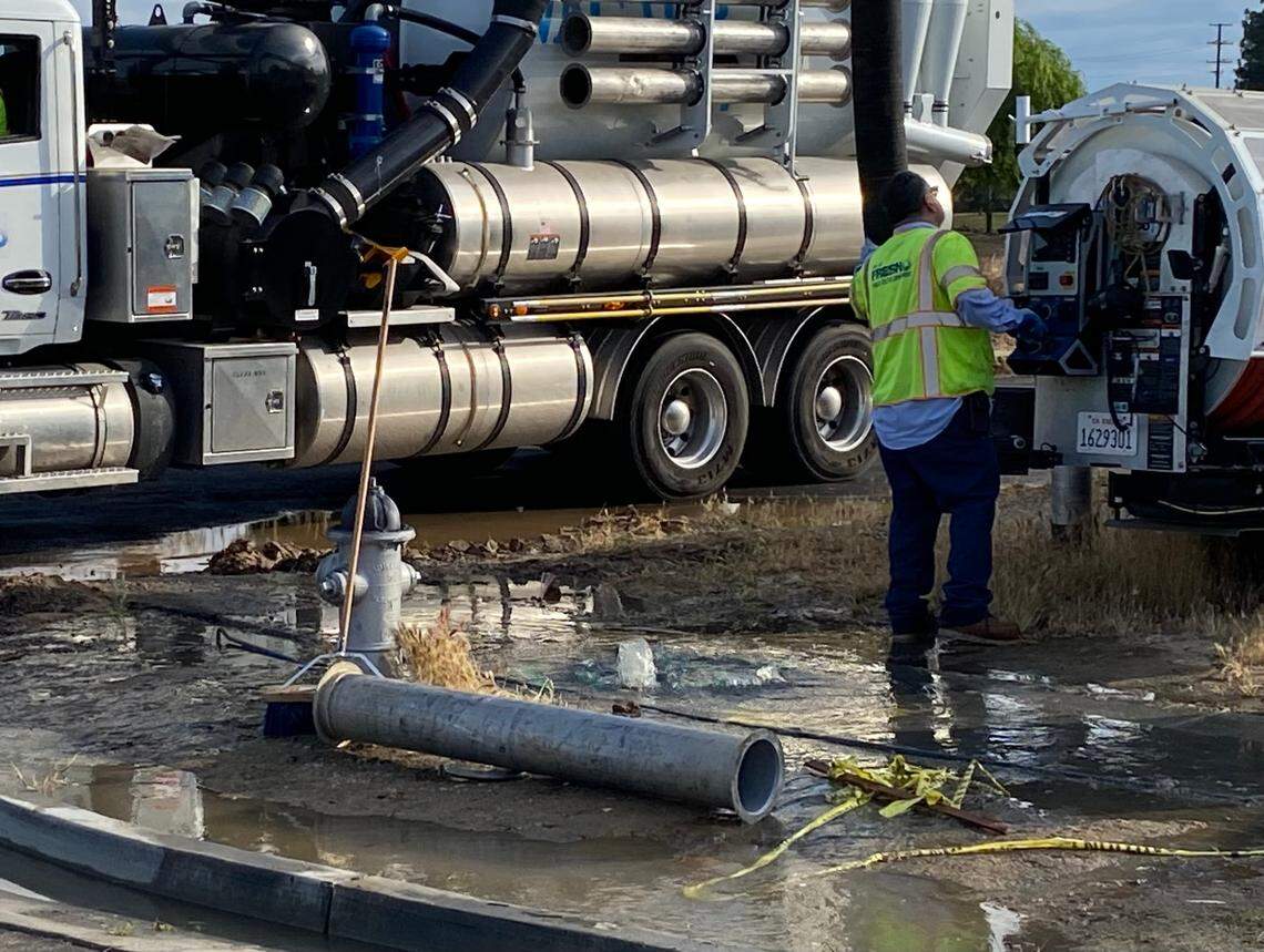 Water bubbles up from a manhole in a cul de sac on Weber Avenue near McKinley Avenue in central Fresno on Saturday morning, May 6, 2023. A broken sewer line a short distance away backed up sewage in the neighborhood, and crews pumped the wastewater into trucks to move it to an undamaged part of the system.