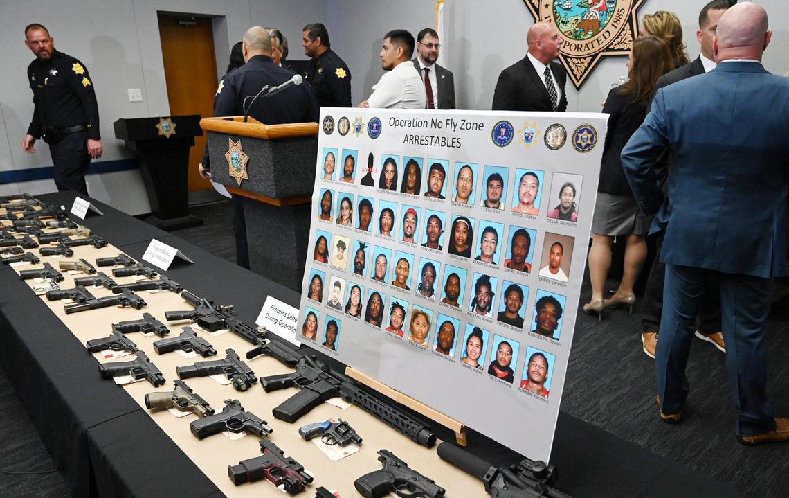 Mugshots and confiscated firearms are seen following a joint press conference announcing the results of a 5-month long investigation into street gangs called No Fly Zone Friday afternoon, April 15, 2022 in Fresno.