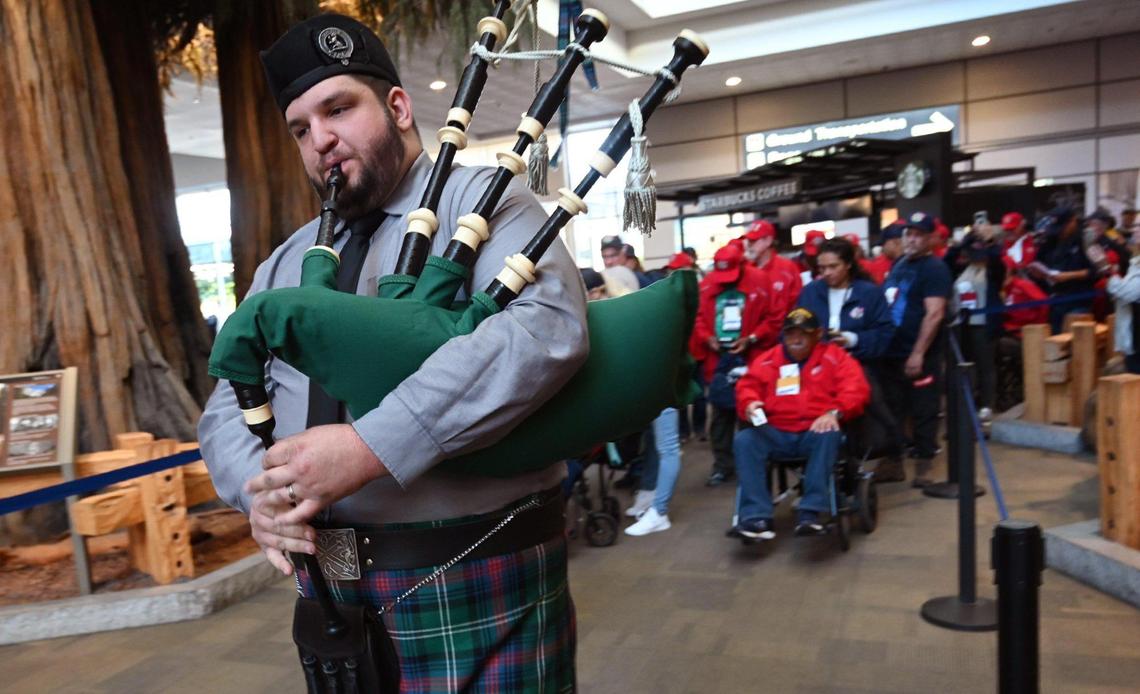 A bagpiper leads 63 veterans in a procession as they board their flight for the Central Valley Honor Flight #21 Monday morning, May 16, 2022 at Fresno Yosemite International Airport.