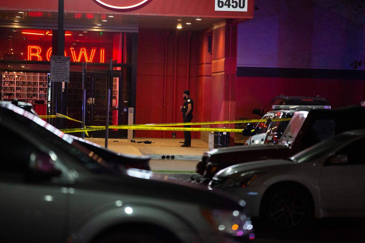A police officer stands by at the scene of a fatal shooting inside a Bowlero bowling alley in northeast Fresno on Friday, Feb. 11, 2022.