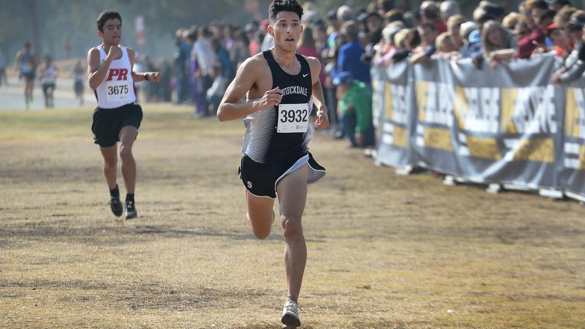 Stockdale’s Marcus Mota, center, pulls away from Paso Robles’ Damian Gavilan to win the Central Section boys Division I cross country championships at Woodward Park on Thursday, Nov. 15, 2018.