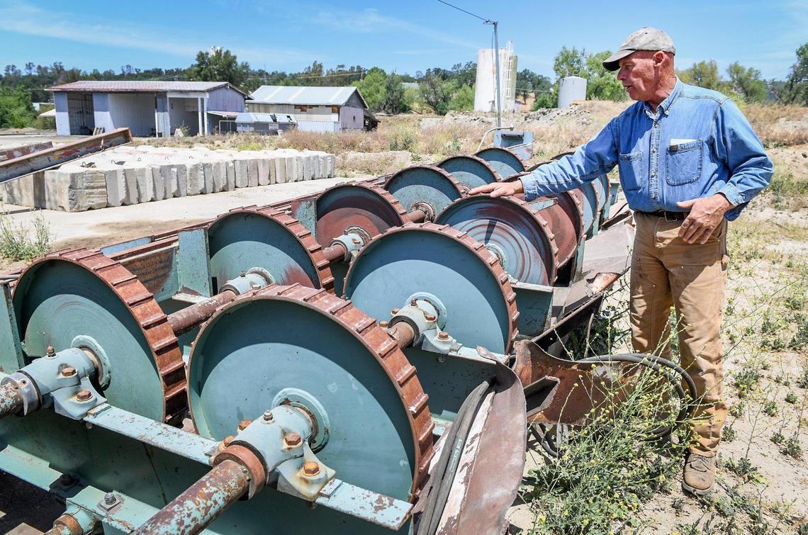Kirk Ringgold looks over a debarking machine on his property while working toward starting up a sawmill operation in Auberry, on Thursday, May 13, 2021.