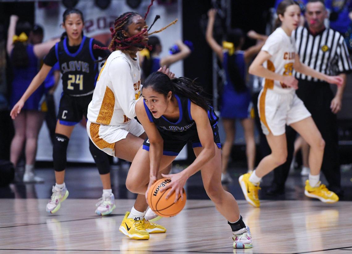 Clovis High’s Genevieve Tamondong, right, steals the ball from Clovis West’s Etoyah Montgomery, background, in the Central Section girls Division I basketball championship Saturday, Feb. 25, 2023 in Fresno.