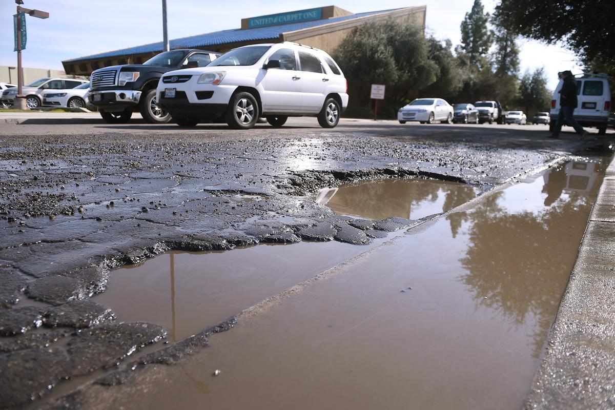 Large potholes create a hazard for vehicles exiting the Jack in the Box at West Shaw and Crystal Avenues Thursday, Feb. 7, 2019 in Fresno.